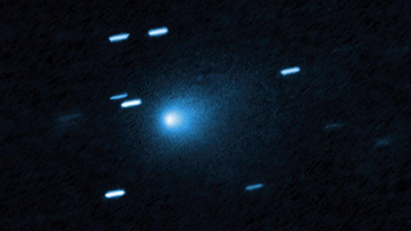 A blue ball of light shines between streaks of blueish light from stars in outer space