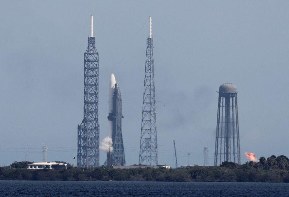Historic Mars mission and Jeff Bezos’ New Glenn rocket’s major debut postponed due to weather 1 Launch pad with a rocket poised for takeoff, surrounded by launch towers and infrastructure, with smoke billowing from the base in preparation for lift-off.